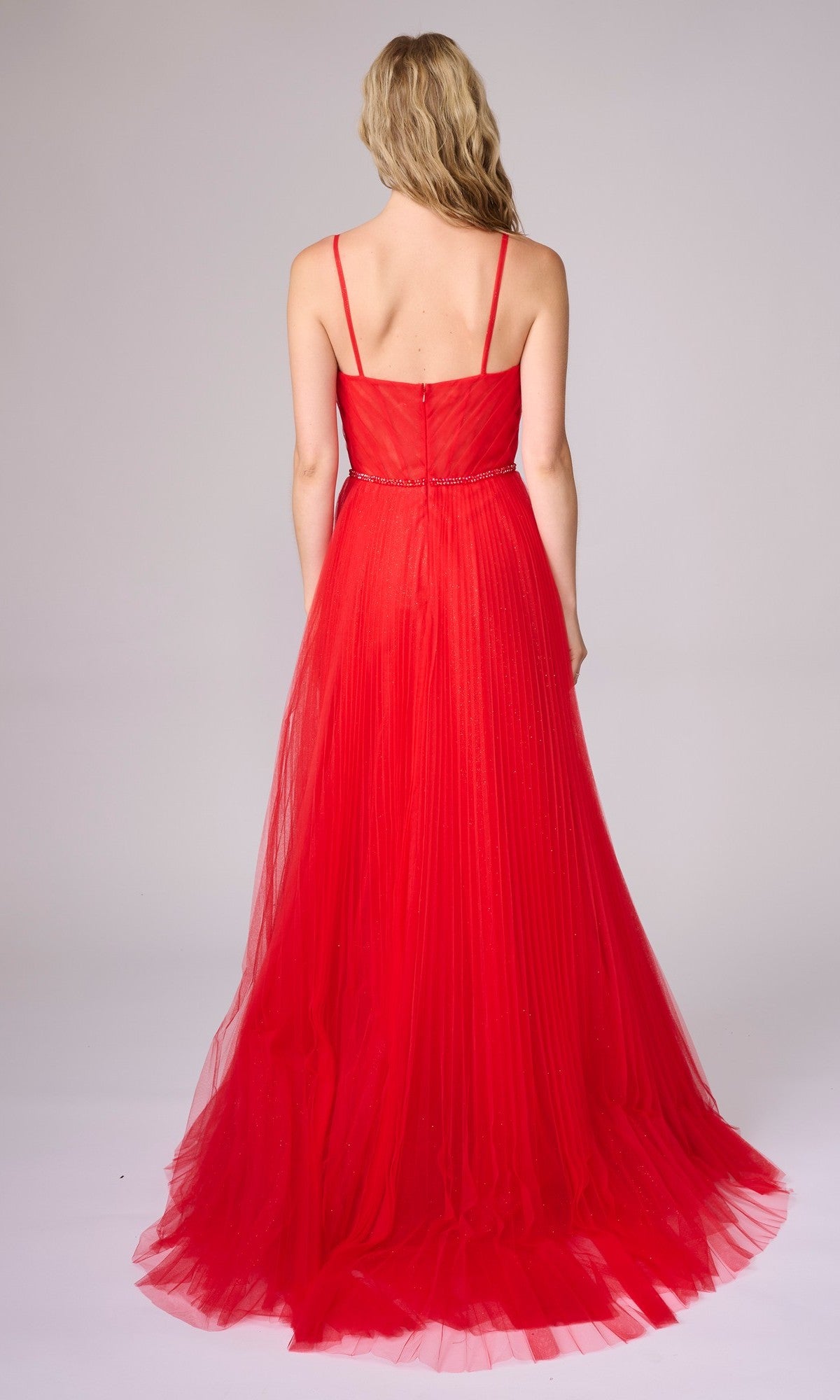 A woman with long blonde hair, facing away, wears the Nina Canacci 5401 sleeveless, floor-length red formal dress featuring thin straps and a fitted bodice against a plain background.